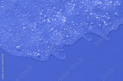 Background from cosmetic gel with bubbles,dripping down.Deep blue color,copy space for text or design.Top view,antibacterial liquid surface.Good as background or mockup.