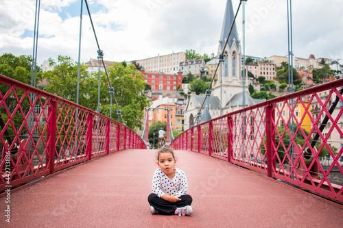 portrait of little girl playing on a bridge on vacation in europe