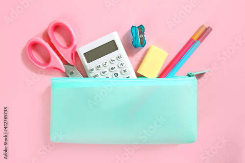 School supplies set top view on pink empty space background. Pencil case with accessories. Back to school