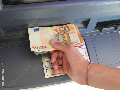 hand picking up banknotes in Europe from an ATM