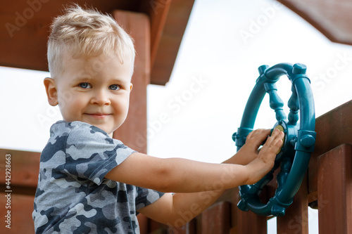Little boy as helmsman on playground, outdoor activity