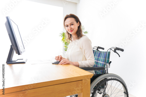車椅子でデスクワークをする外国人の女性