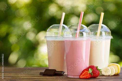 set of different milkshakes in disposable plastic glasses