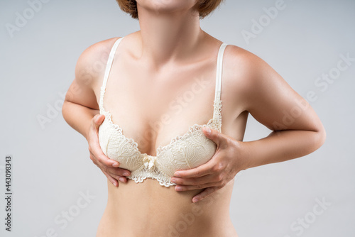 Woman in a beautiful lace push-up bra on a gray background