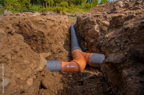 laying sewer pipes in the ground under the foundation. braiding several pipes into one