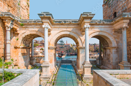View of Hadrian's Gate in old city of Antalya - Old town (Kaleici) in the background Konyaalti beach and mountains - Antalya, Turkey