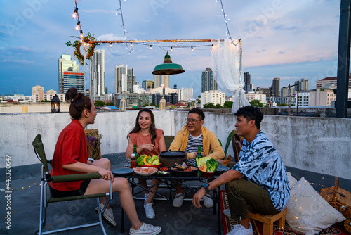 Group of Diversity Asian millennial people friends enjoy outdoor dinner party with eat korean food barbecue grill and alcoholic drink at rooftop for meeting reunion and holiday celebration together