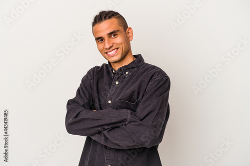Young venezuelan man isolated on white background who feels confident, crossing arms with determination.