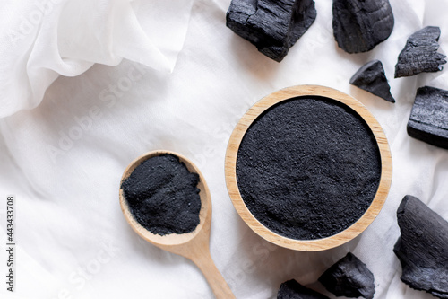 The black charcoal powder in the wooden cup was placed on a white cloth.