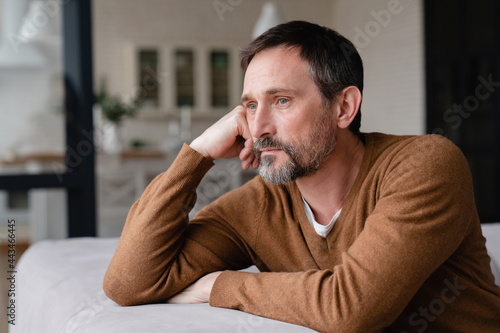 Bored tired sad mature middle-aged man depressed lonely having no visitors of his children. Divorce , bachelor , health problems concept. Lockdown, unemployment, needless man on social distance