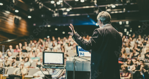 Public speaker giving talk at Business Event.