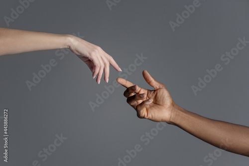 Male and female hands reaching out to each other copying creation of Adam sign.