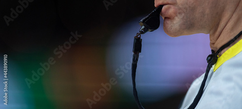 Referee with whistle on colorful background. Professional sport concept