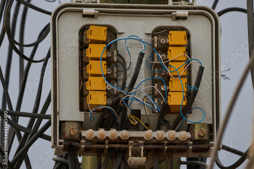 Caja de conectores de señal telefónica e internet con conectores amarillos y cables azules todos enredados 