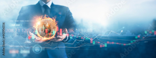 Hands of businessman and gold bitcoin coin in fire with volatile business graph on global network, Financial, Stock market, Cryptocurrency and investment.