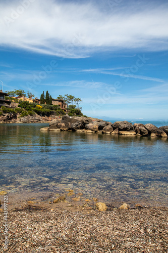 Italian rocky beach with small harbour and big villa. Holiday in Italy in summertime, seascape travel destination