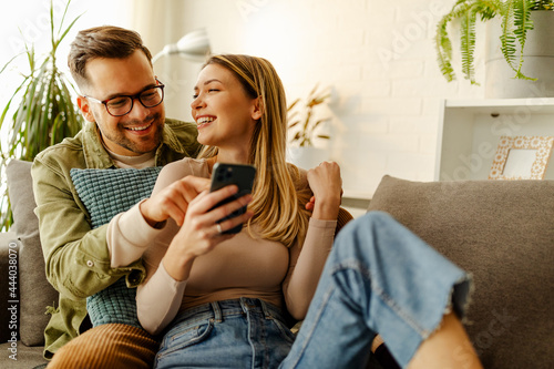 Overjoyed young couple triumph celebrate read good unexpected news on smartphone.