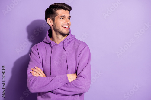 Portrait of attractive content cheerful guy folded arms looking aside copy space isolated over purple violet color background