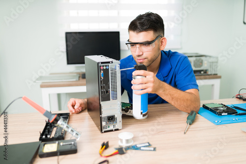 Professional technician using compressed air