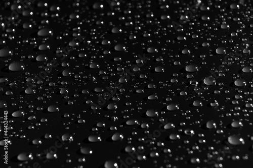 drops of water on a black background. dew on the surface.