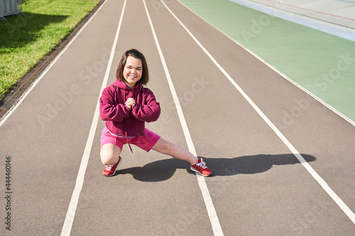 Midget woman doing stretching at the stadium at the morning