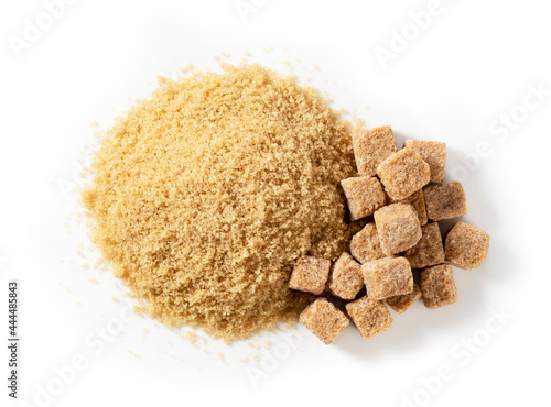 Brown cane sugar powder and sugar cubes on a white background.