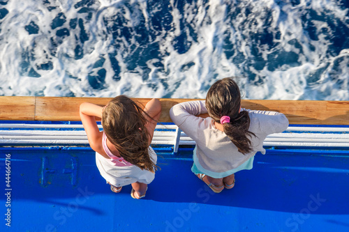 Beautiful Summer Scenery of two young children staring at the deep blue sea of aegean in Greece