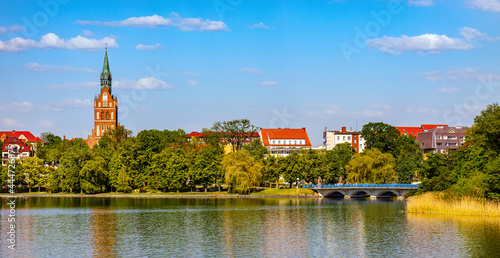 Panorama of Elk historic city center with Holiest Heart of Jesus neo-gothic church tower on shore of Jezioro Elckie lake in Masuria region in Poland