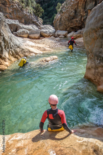 Unrecognizable people canyoning in summer in Barranco Oscuros, Sierra de Guara, Aragon, Spain