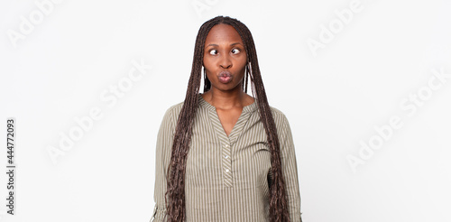 afro black adult woman looking goofy and funny with a silly cross-eyed expression, joking and fooling around