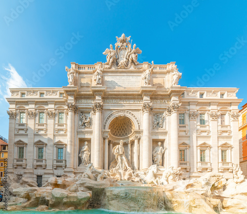 Front view of world famous Trevi fountain under a blue sky