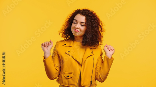 proud young woman in leather jacket isolated on yellow