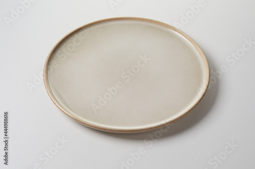 Circular clean generic pottery plate in a neutral beige