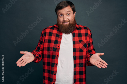 Handsome silly forgetful guy feeling sorry, apologizing late meeting, spread hands sideways indecisive shrugging and smiling awkward, make excuses trying solve troublesome situation, grey background