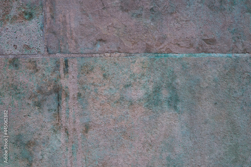Green copper patina on a stone wall