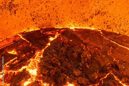 The surface of a hot liquid slag in a metallurgical ladle. Thick crust covered with trash net