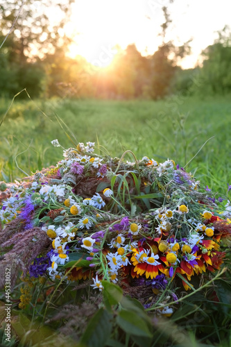 wreath of wild flower on sunny meadow. Summer Solstice Day, Midsummer concept. floral traditional decor. pagan witch traditions, wiccan symbol and rituals
