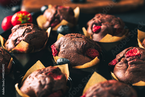 Muffin. Chocolate muffins with stawberry. Muffins on wooden stand.