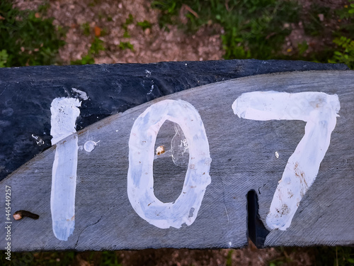 Top view of 107 written on a wooden fence in a field with a blurry backgroun