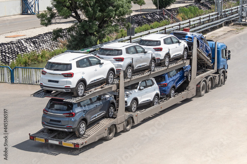 Car carrier trailer transporting new automobiles on road