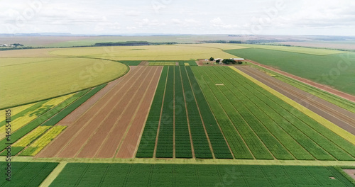 Aerial flying over fields with straw bales at harvesting time. Soybean, sunflowers and maize or corn.