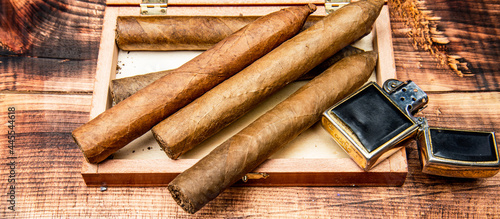 Cigars in box and vintage lighter. Cuban cigars wooden background. Cigar smoking. Cigar tobacco