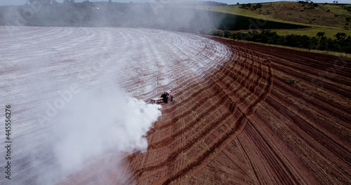 Tractor applying limestone to the soil to correct acidity