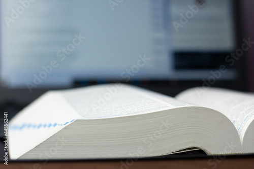 Closeup of a dictionary and CAT (Computer-Assisted Translation) tool in the background.