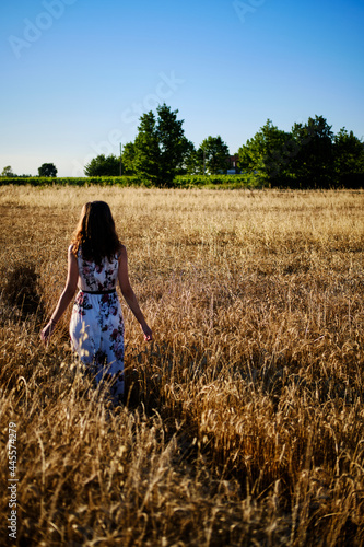 Foto scattata ad una ragazza in un campo di grano prima della mietitura.