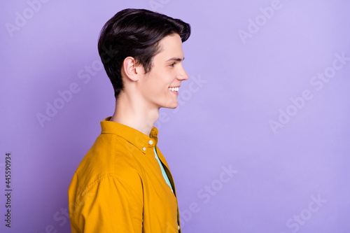 Profile photo of optimistic brunet millennial guy look empty space wear brown shirt isolated on violet color background