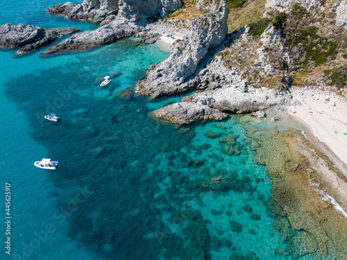 Aerial view of moored boats floating on a transparent sea. Scuba diving and summer holidays. Capo Vaticano, Calabria, Italy. Promontory. 