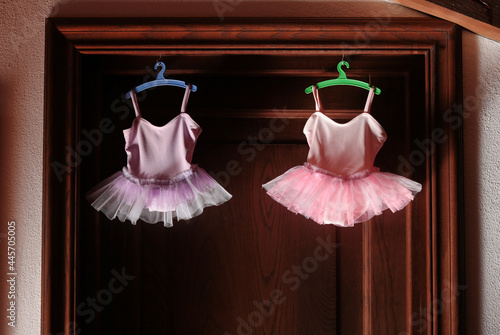 tutu for babies on colored hangers over a wooden door