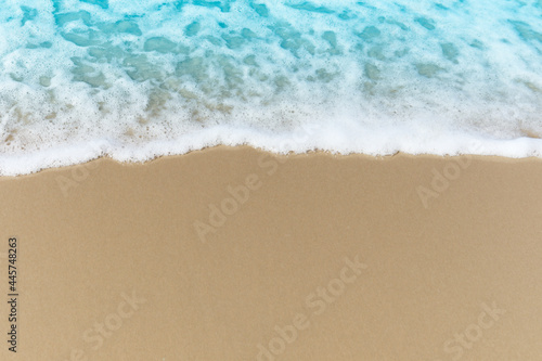 Blue ocean waves with white foam crashing on summer sand beach island top view with copy space, beautiful natural scene of tropical sand beach background.
