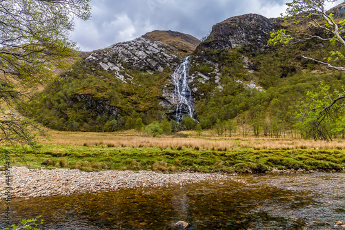 A view from the bank of the River Nevis towards the Steall Waterfall in Glen Nevis, Scotland on a summers day
